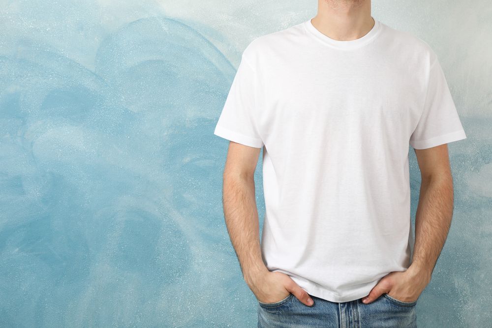 Men in blank t-shirt against blue background, space for text