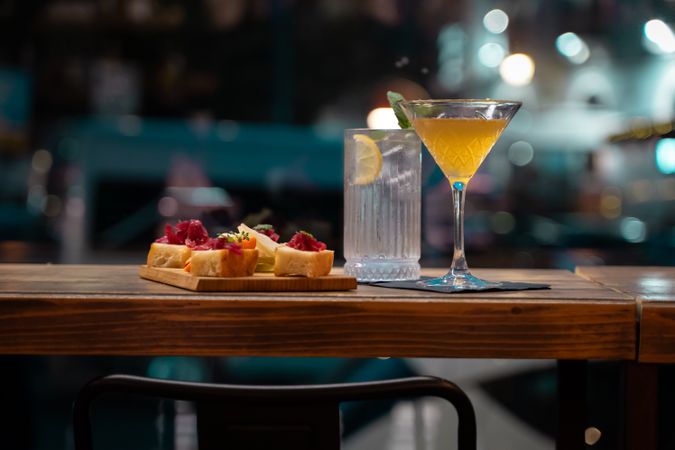 Elegant cocktail and appetizer platter in a stylish bar at night