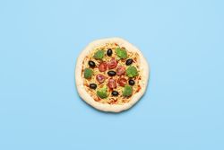 Vegetarian pizza uncooked on blue table