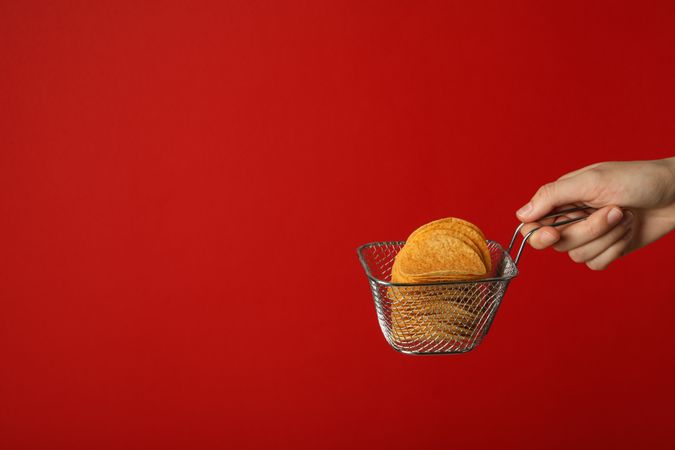 Deep-fried potato chips on a red background