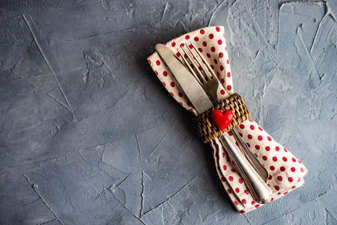 St. Valentine day table setting with dotted napkin wrapped cutlery