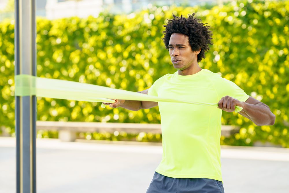 Man pulling back on resistance bands with arms