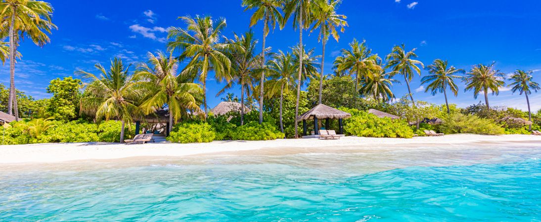 Wide shot of tropical beach resort with cabanas