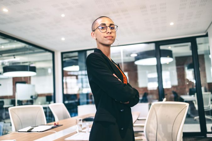 Confident female entrepreneur looking at the camera in an office with arms crossed