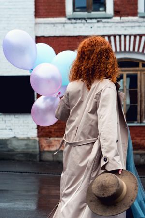 Woman walks streets with bunch balloons