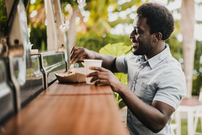 Young man eating in food truck counter