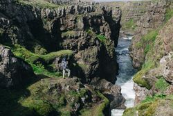 Man on edge of rugged cliff on a sunny day