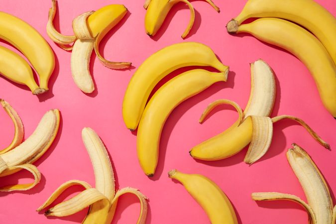 Bananas and apples on pink background, top view. Fresh fruit