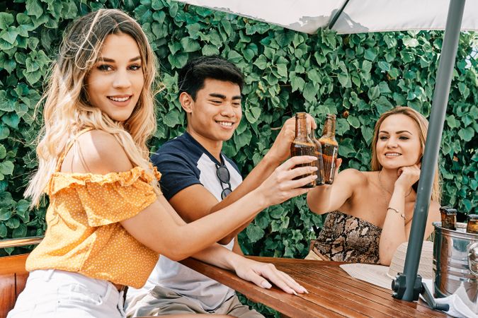 a group of young people cheering with beer in summer