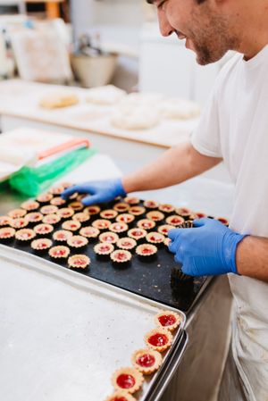 Anonymous baker decorating small cakes