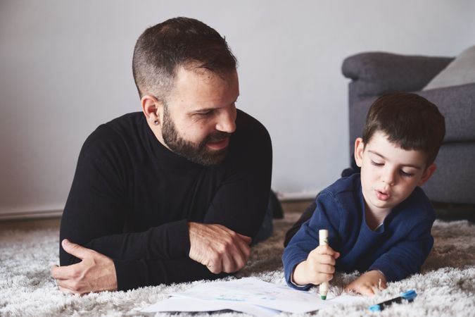 Father and son drawing on floor