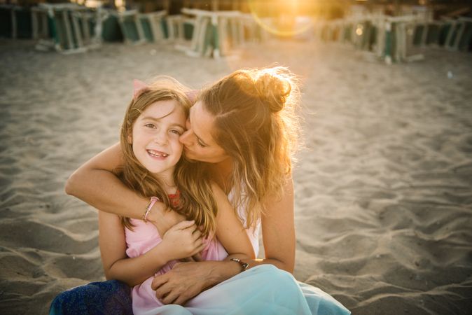 Woman with daughter on sunny beach