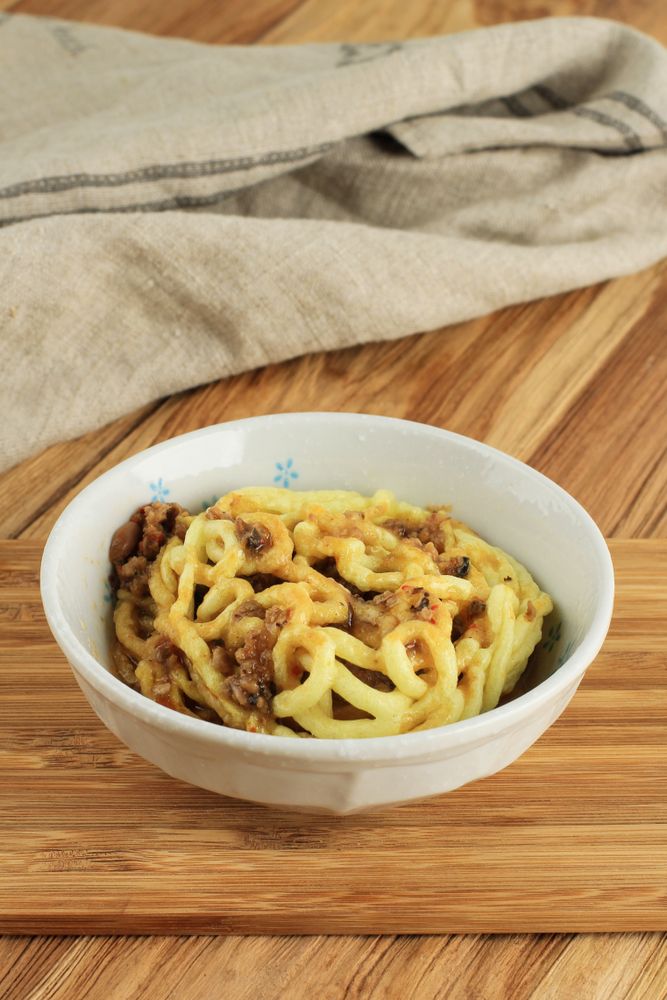 Crispy kerupuk mie banjur sambel oncom mixed with sauce in bowl