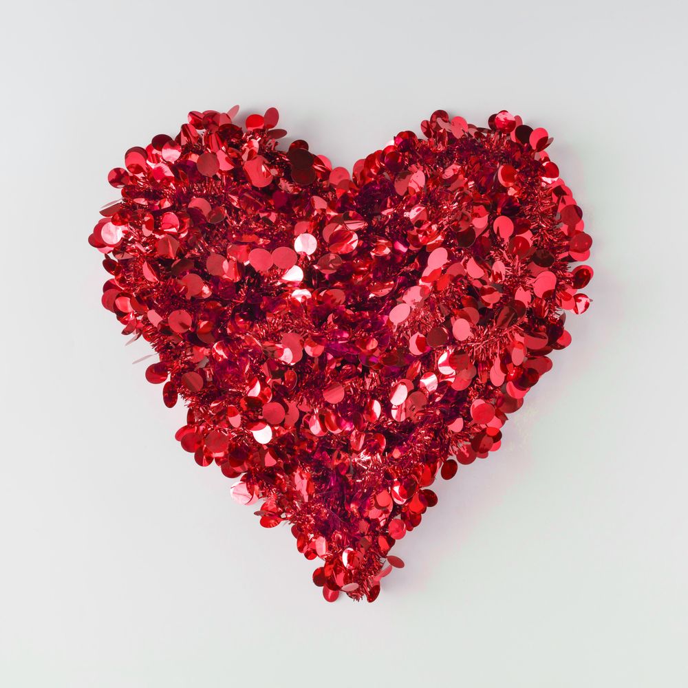 Red confetti shaped in heart on light background