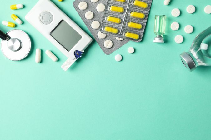Diabetes accessories on mint background, top view