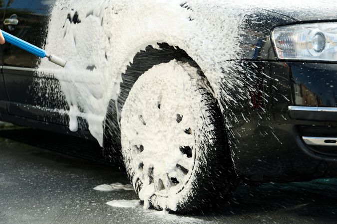 A man washes a car with foam. Clean car concept. Car wash