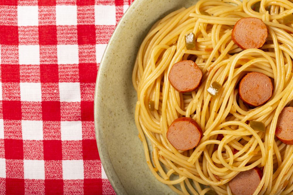 spaghetti pasta with sliced sausages and tomato sauce.