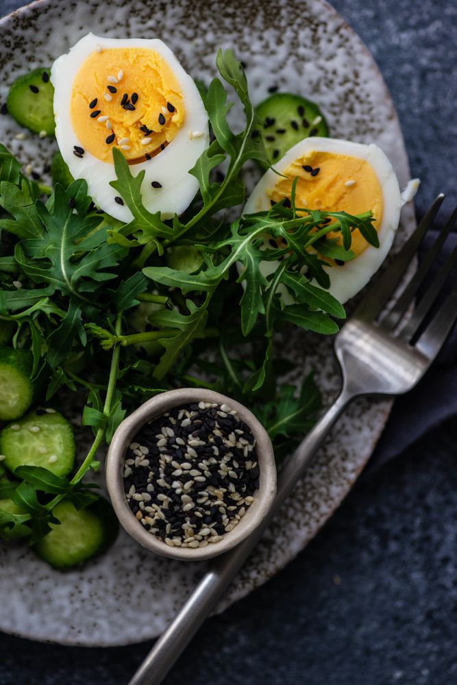 Bowl of healthy salad with hard boiled egg and cucumbers