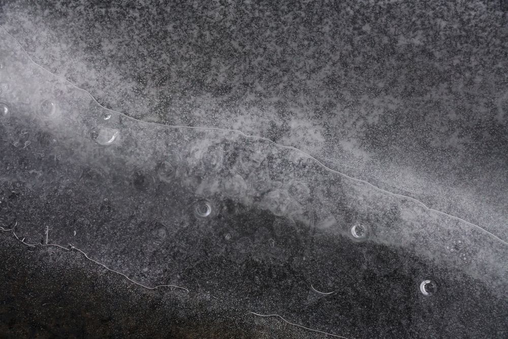 Fragment of thin ice on dark frozen river