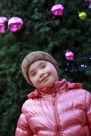 Female child standing in front of a christmas tree
