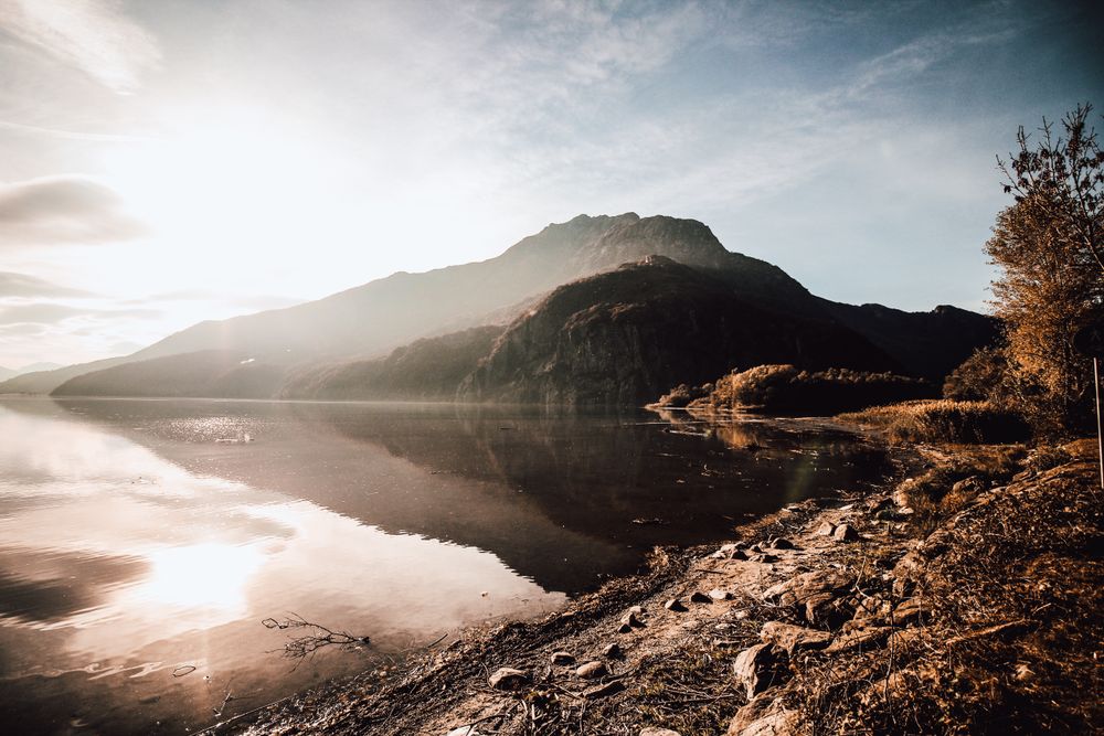 Cloudy sky over mountain with reflection on  glassy calm lake