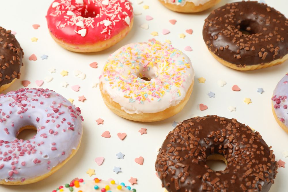 Flat lay with tasty donuts on plain background