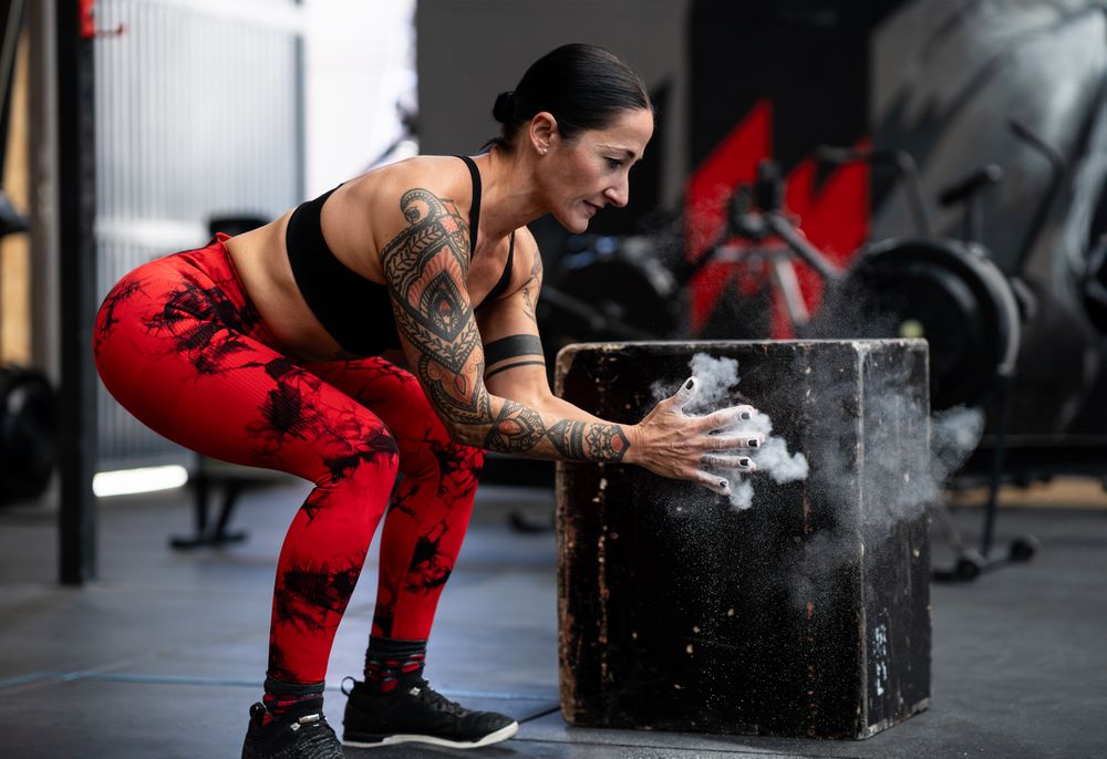 Woman dusting hands before weightlifting