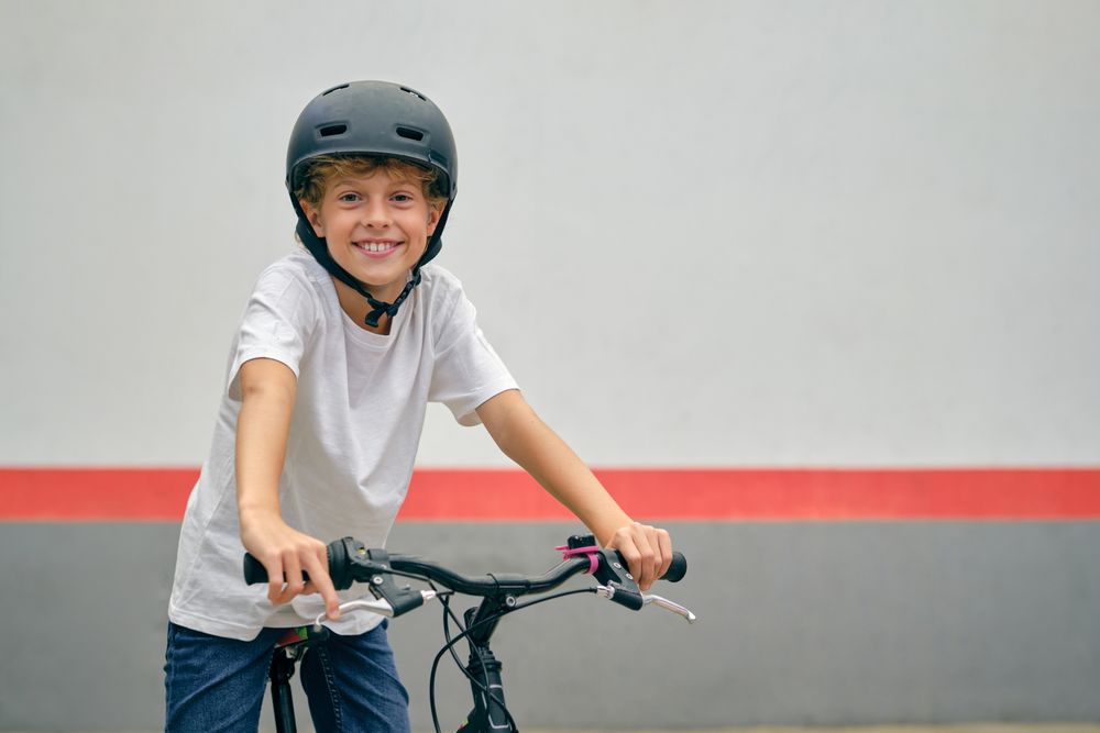 Smiling boy in helmet sitting on bicycle