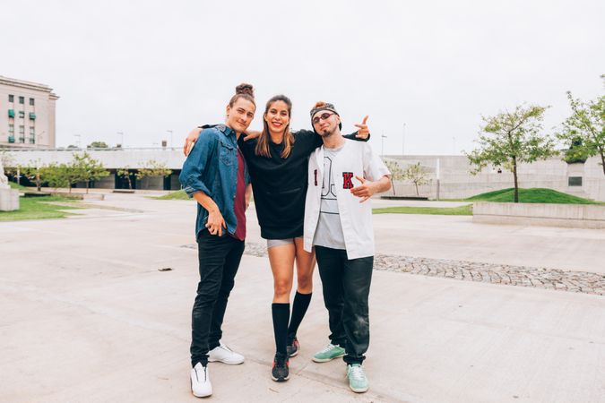 Cheerful friends in embrace at city street