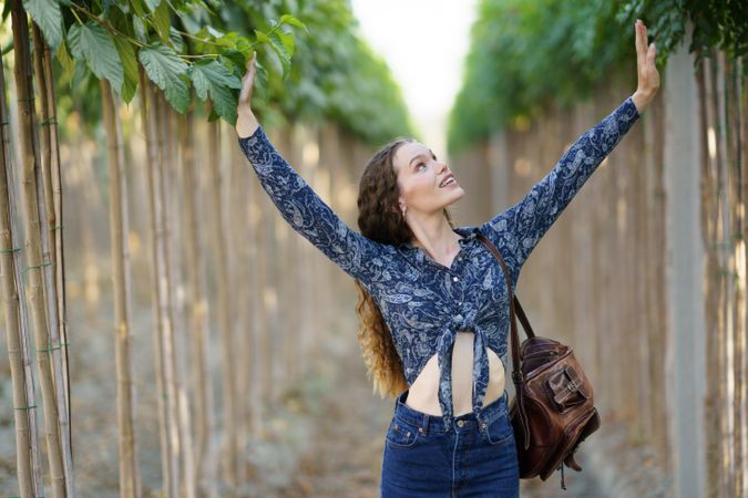Joyful Woman Embracing and Connecting with Nature in a Beautiful Lush Green Environment