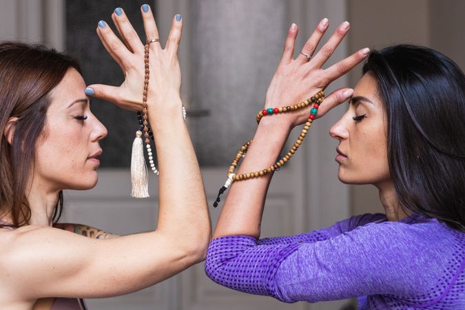 Young women meditating with closed eyes during yoga training