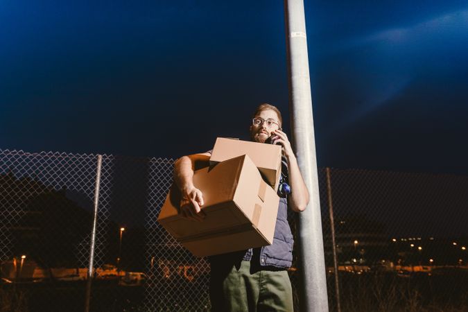 Dedicated courier phoning for delivery completion while waiting client on street in evening