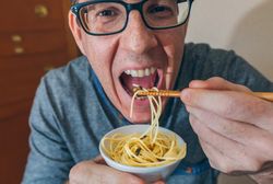 Man eating spaghetti and crickets