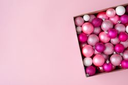 Box of pink festival baubles on pink background