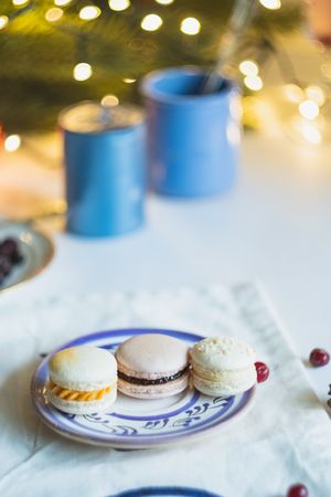 Variety of festive macarons on table with Christmas lights