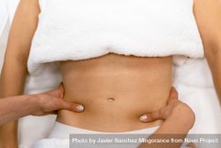 Massage therapist working on a female client’s abdomen beRLA0