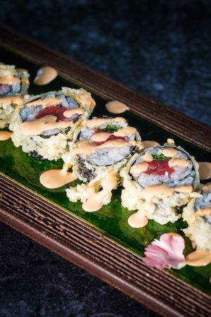 Tasty sushi rolls served on tray on marble surface