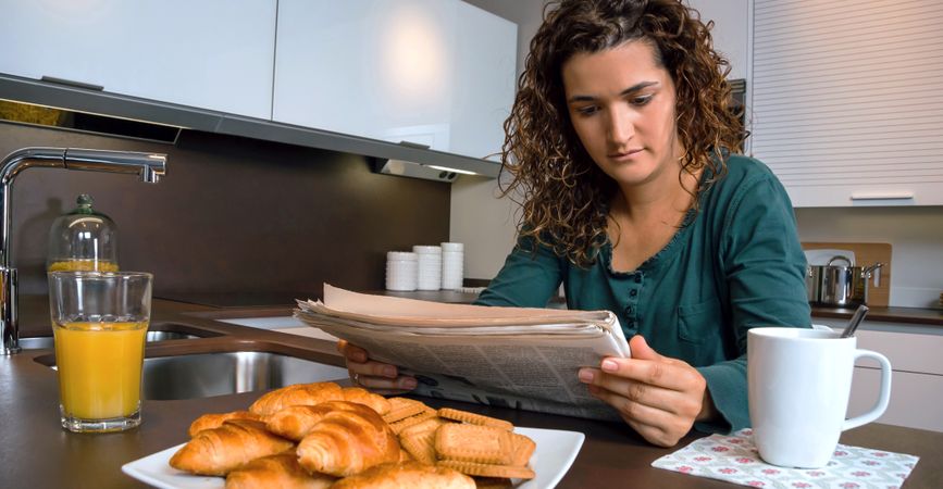 Female reading paper at breakfast tablet