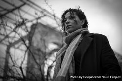 Grayscale photo of woman in coat and scarf standing outdoor 4Nxae0