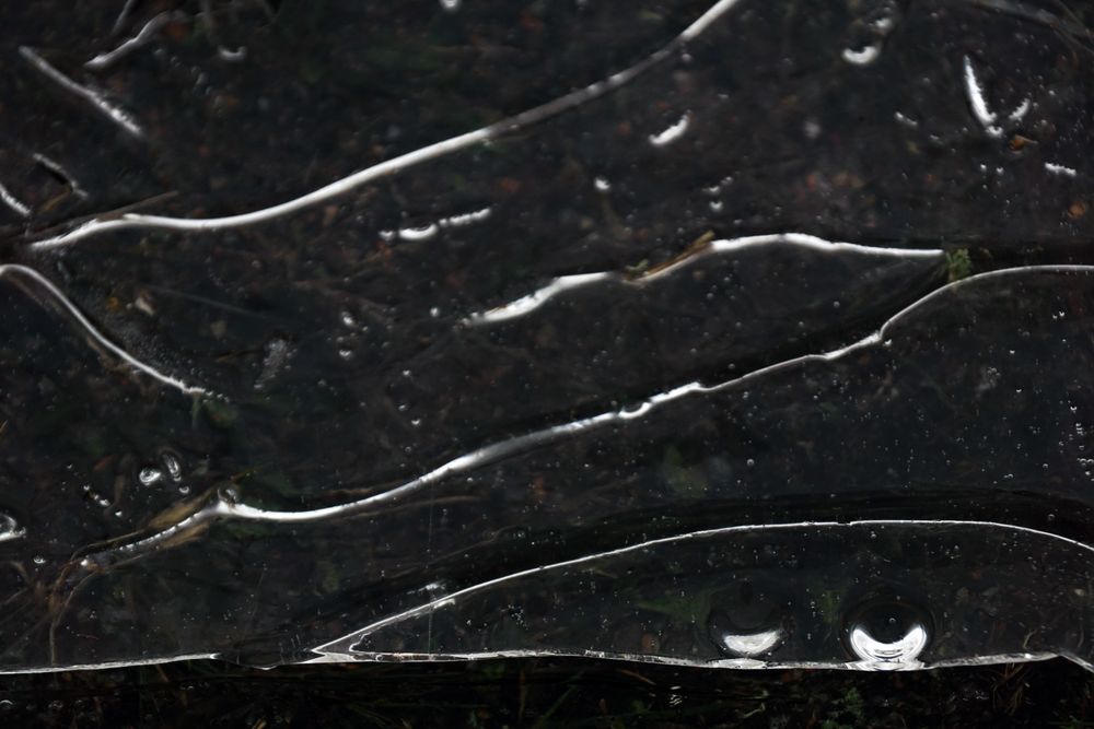 Fragment of thin ice on dark frozen river