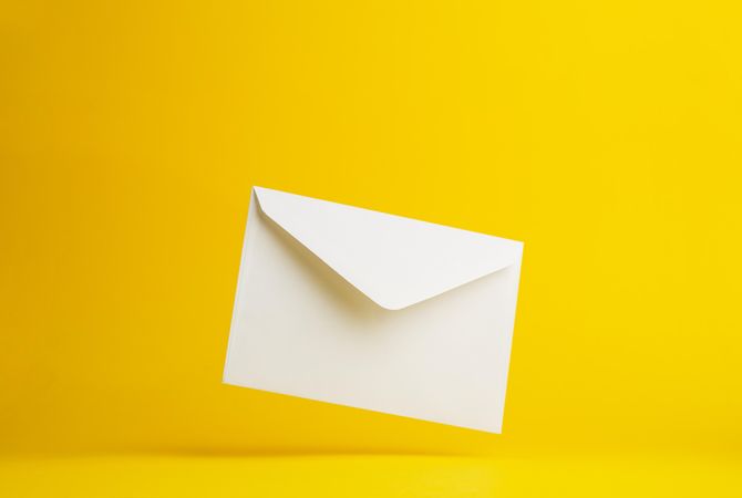 Diagonal floating envelope over light yellow background