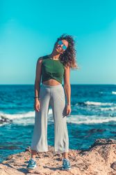 Stylish woman standing near sea