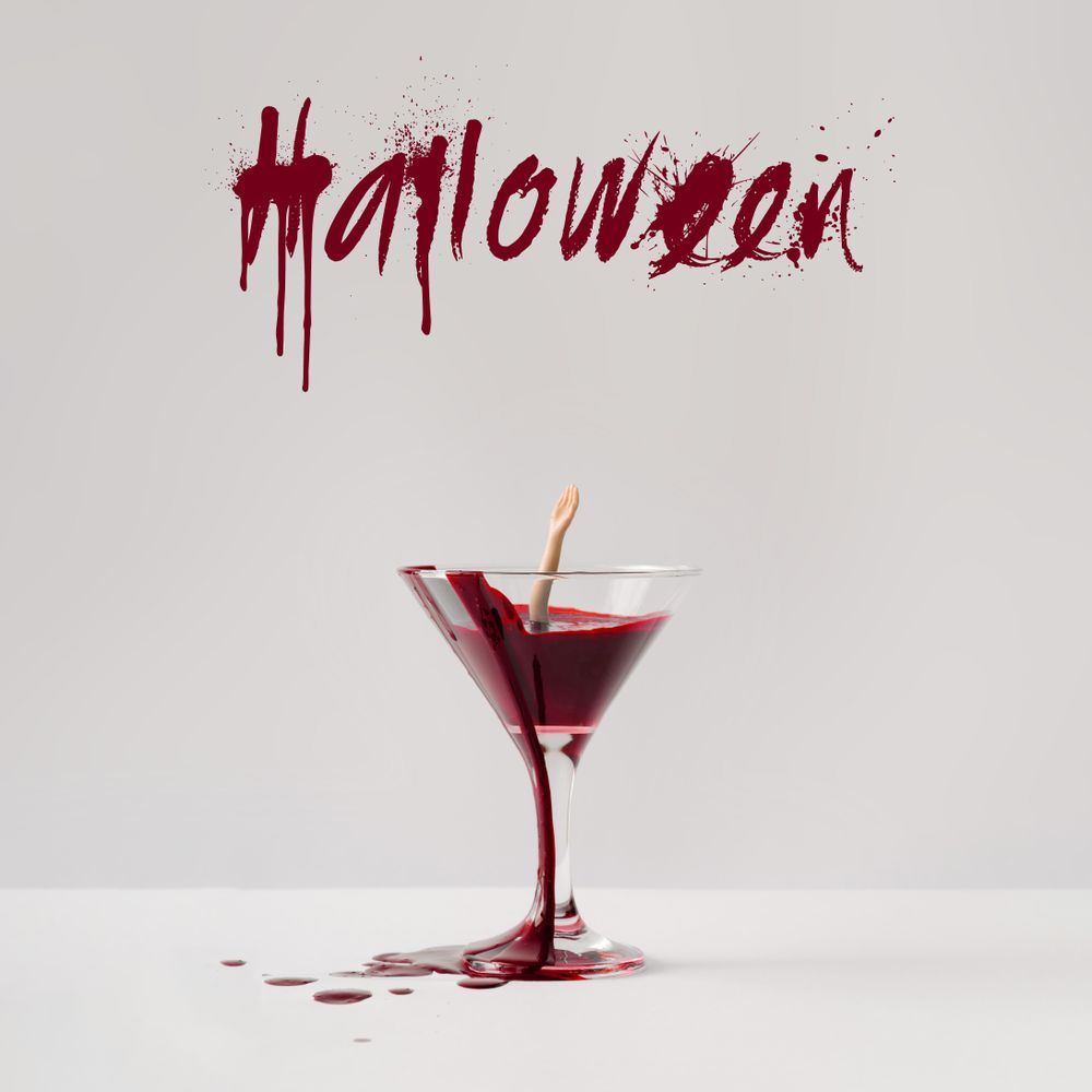 Doll hand drowning in martini glass full of blood with “Halloween” text