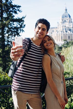 Happy young couple taking selfie in park