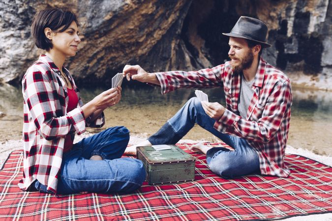 Casual couple playing cards on shore