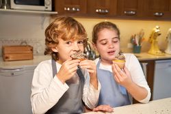Children eating dessert in kitchen