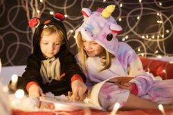 Kids reading Christmas fairy tales in bed