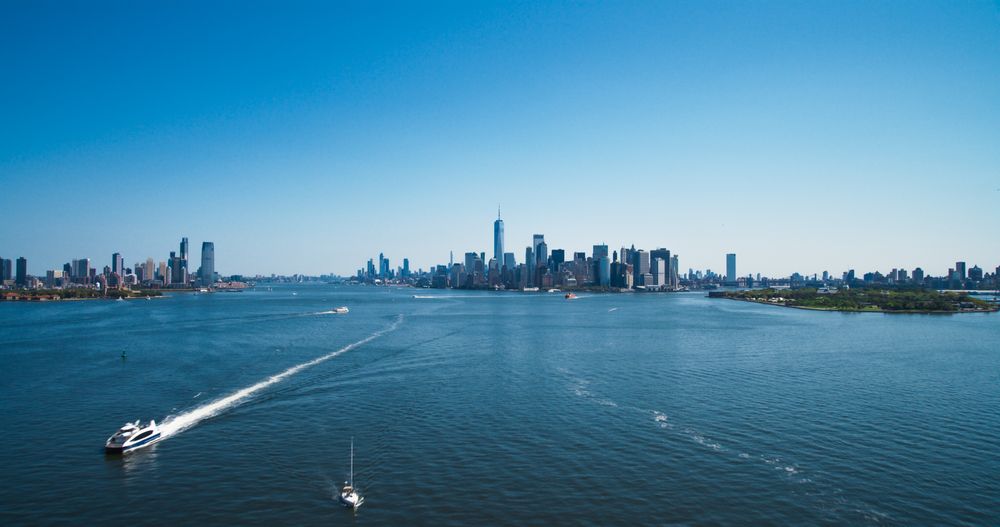 Aerial View of Lower Manhattan Architecture. Panoramic Photo of Wall Street Financial District from a Helicopter. Cityline Scenery with Water Transportation in the Hudson River