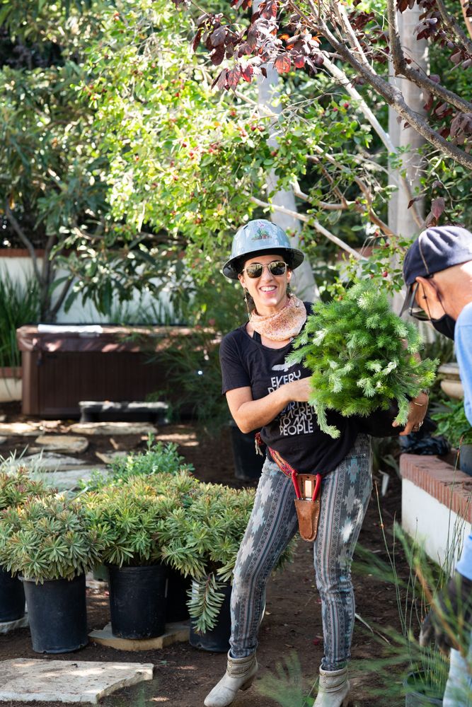 Woman holding plant working in garden