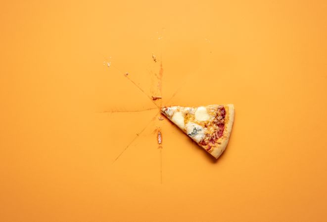 Single pizza slice on orange background